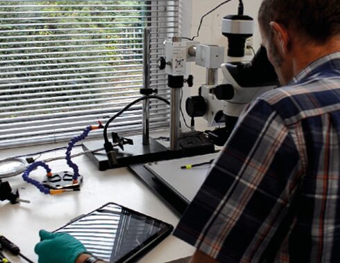 James Morris using the microscope in laboratory